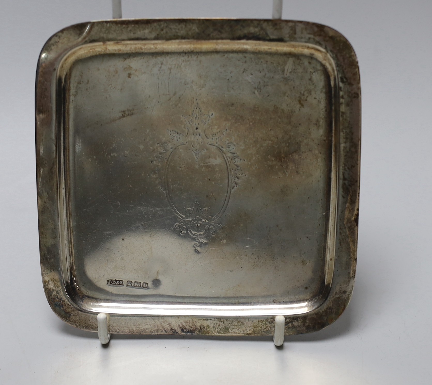 A George V small square silver dish by James Dixon & Sons and three silver napkin rings.